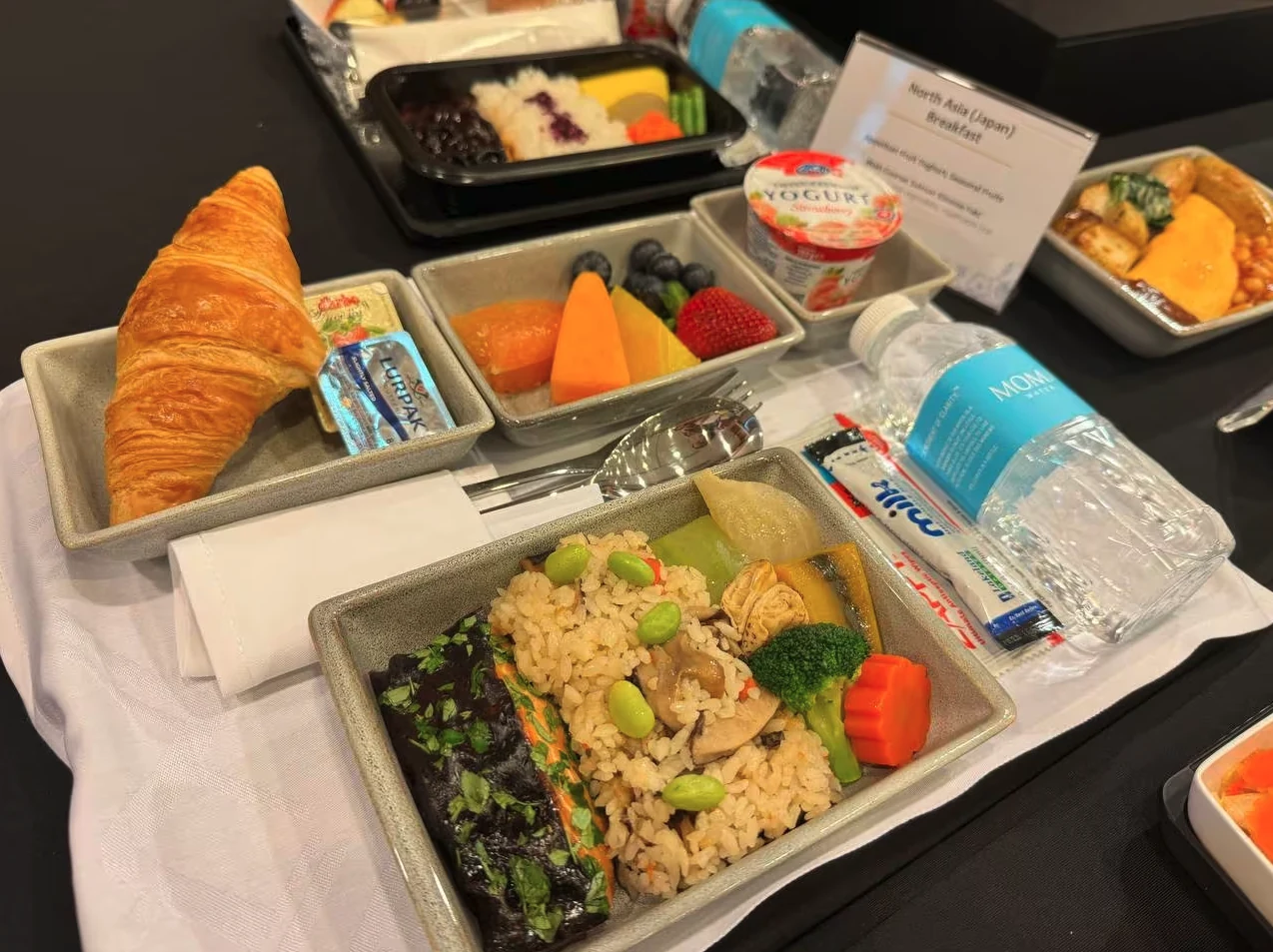 A Singapore Airlines breakfast tray set with a MOMAwater bottle.