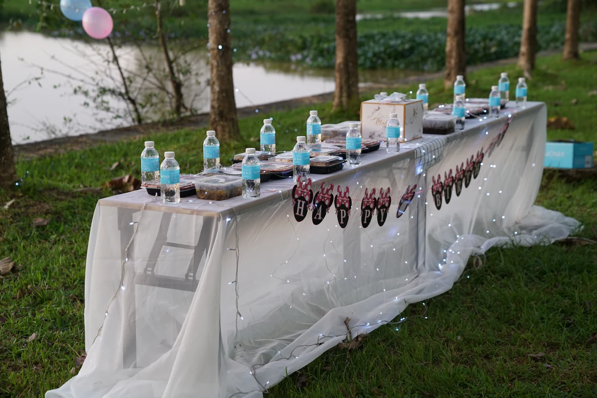 A long banquet table at golden hour, a MOMAwater bottle at every place setting.