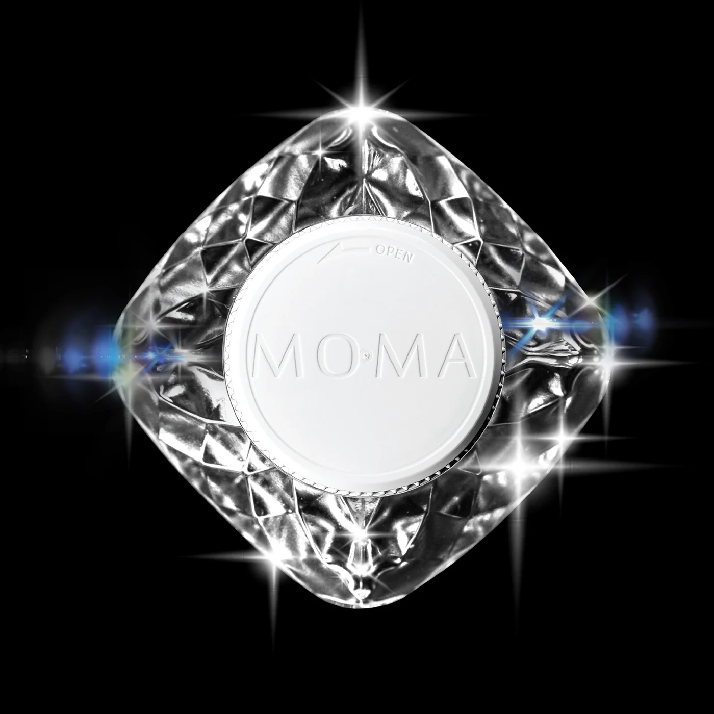 The MOMAwater cap from above, set in the faceted shoulder — a diamond catching the light on black.
